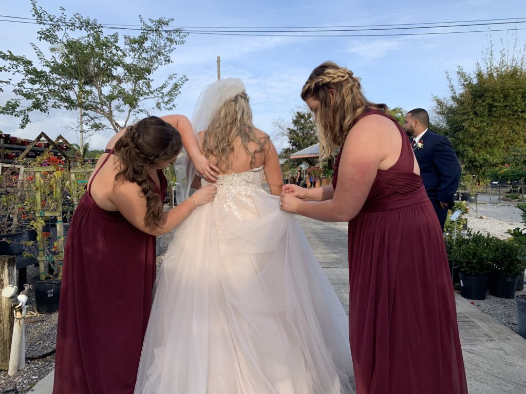 Bridesmaids help to bustle a bride's dress